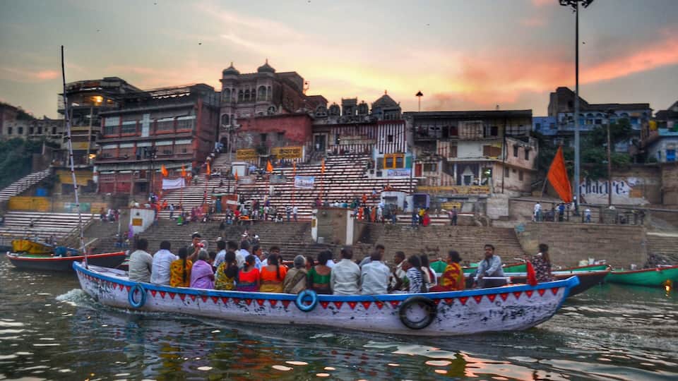 Ganga Aarti performed at dusk on the banks of the Ganges River in one of the oldest living cities in the world. Boats are filled to the brim with people wanting to watch the performance.