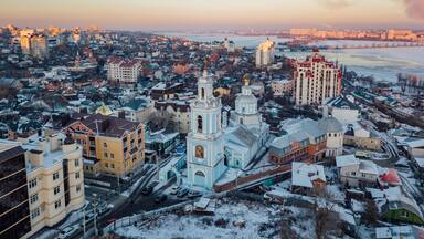 A cityscape with snow-covered buildings and a prominent church with a golden dome.