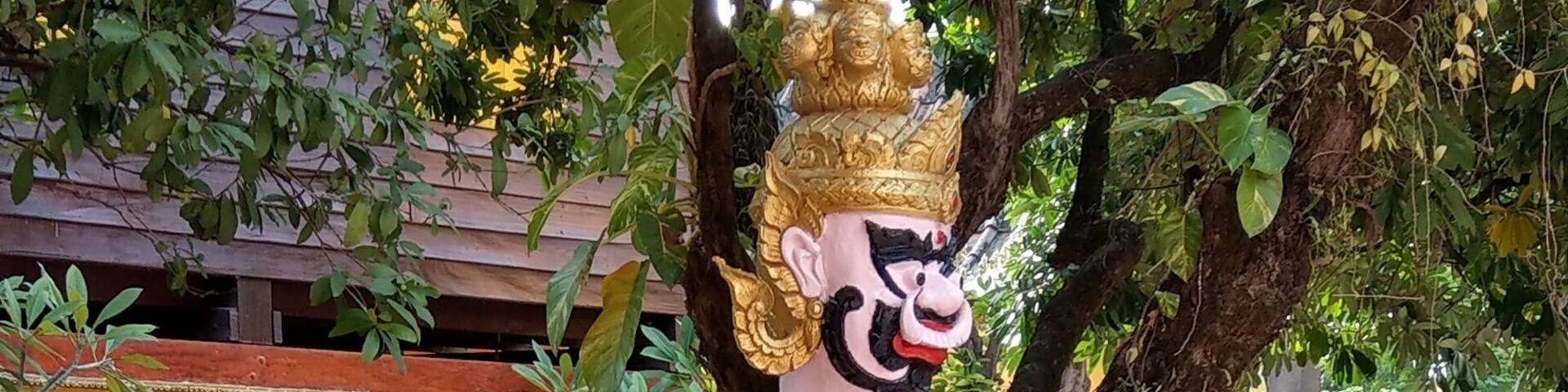 A monk touching up the gold leaf at Wat Si Muang Vientiane