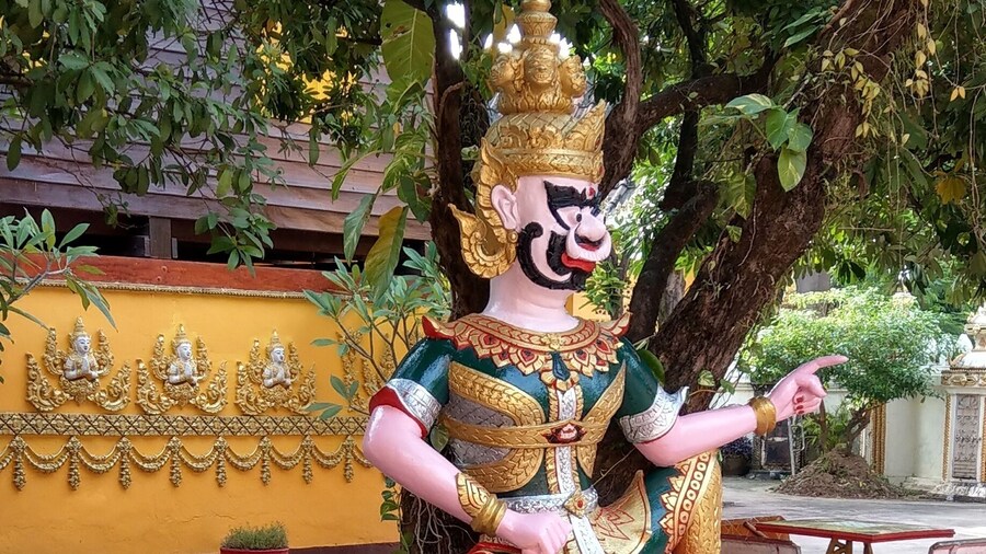 A monk touching up the gold leaf at Wat Si Muang Vientiane