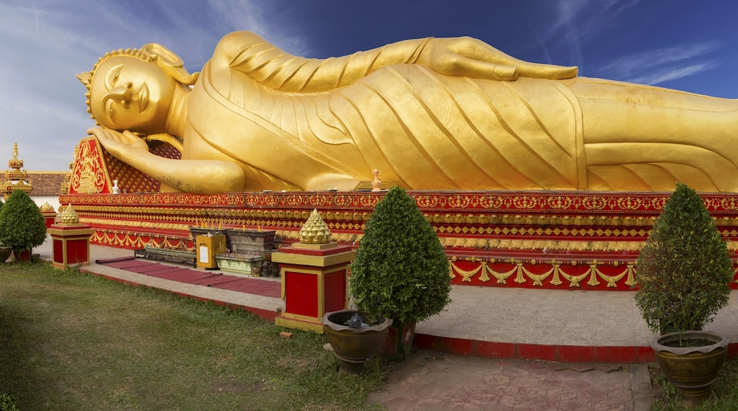 Wide Panoramic View of Reclining Gold Covered Buddha Statue or the Great Stupa, a sacred Buddhist Monument in Pha That Luang, Vientiane, Laos Capital