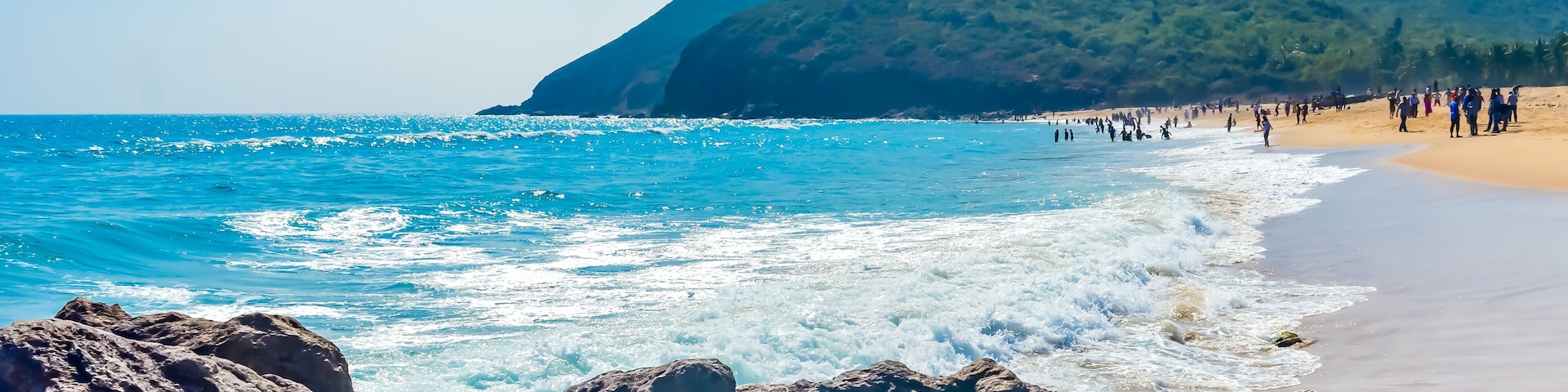 Yarada Beach, Visakhapatnam, India 10 December 2018 - People relaxing and enjoying in Yarada Beach. The Coast area is surrounded by hills and Bay of Bengal with lush green trees and golden soft sands.