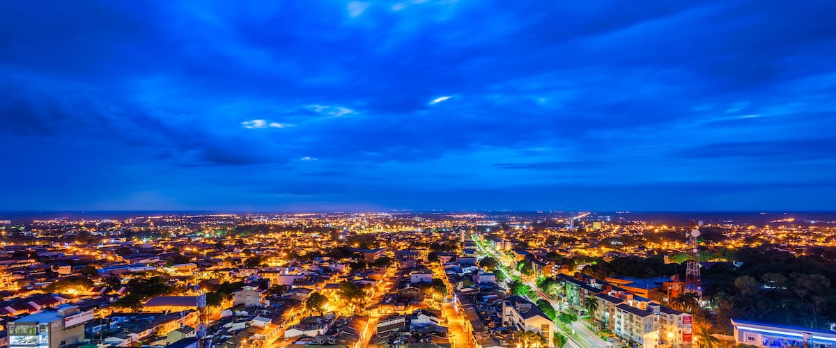 A cityscape at dusk with a vibrant sky and illuminated streets.