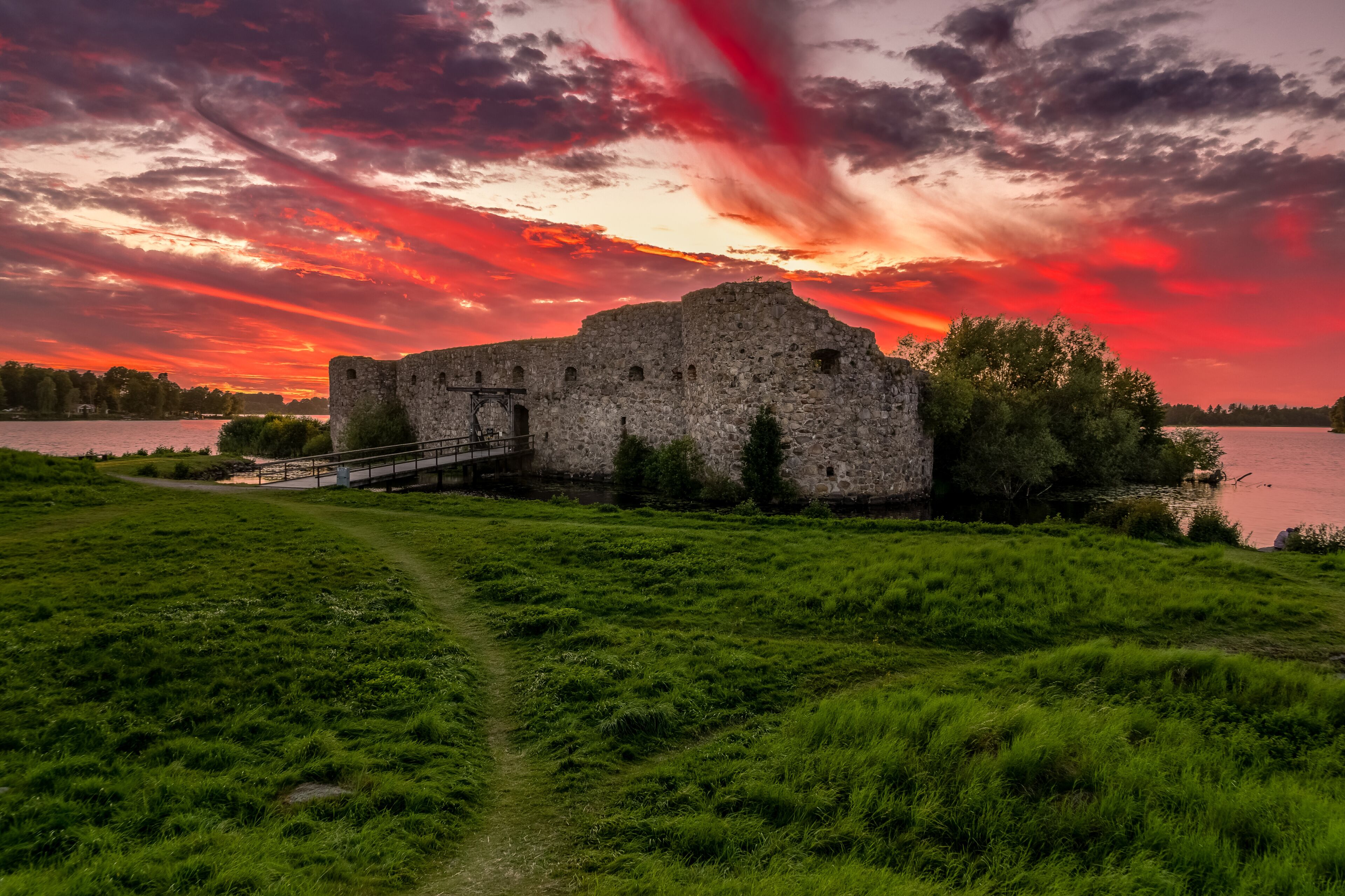 Aerial view of Kronoberg castle ruin on Helgasjön lake in Växjö Municipality in southern Småland, with dramatic sunset sky