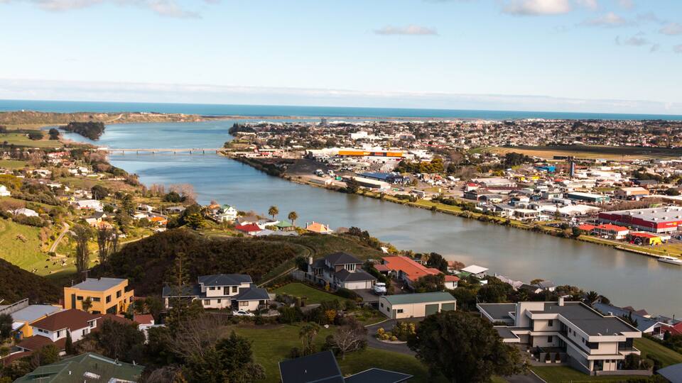 A river flowing through a town with houses and buildings on both sides.