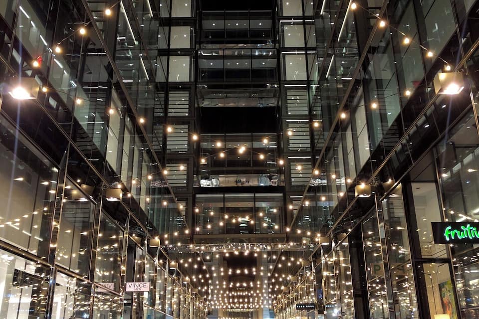 A modern building with glass facades and string lights.