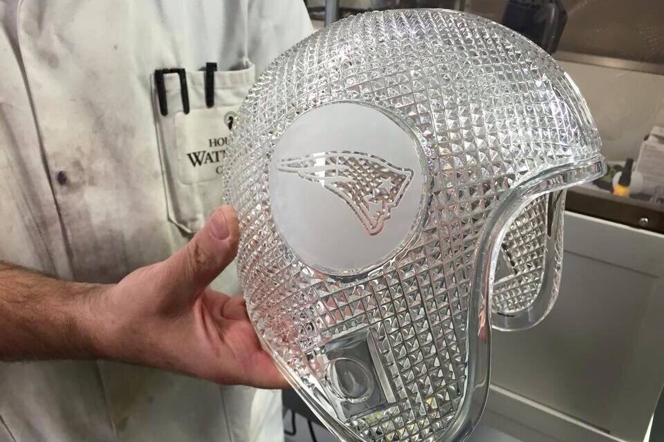 A person holding a helmet with a diamond plate design.