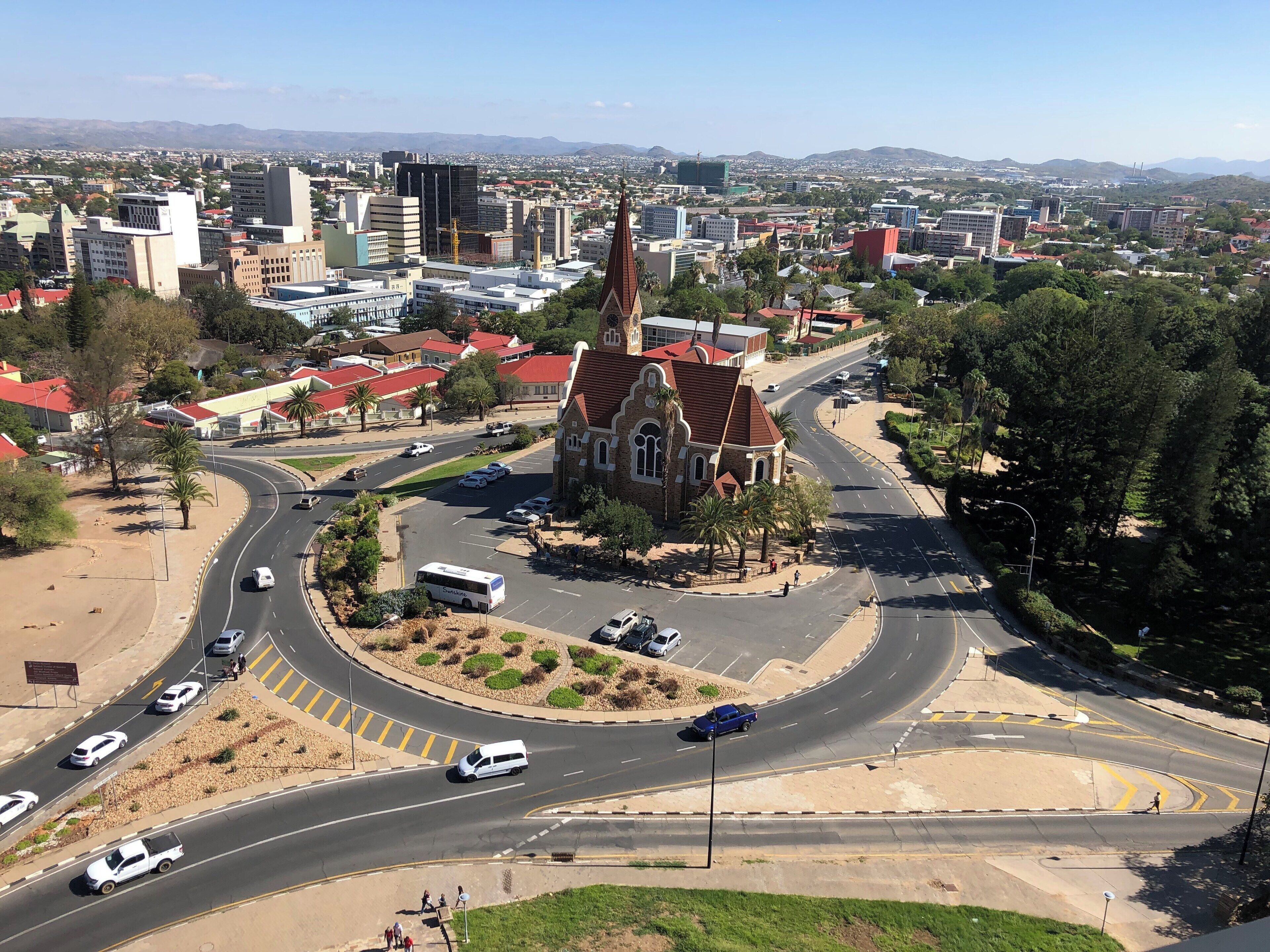A cityscape with a prominent church, a roundabout, and a distant mountain range.