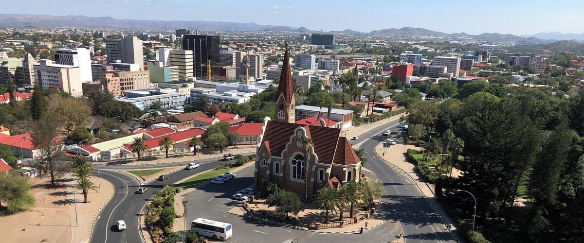 A cityscape with a prominent church, a roundabout, and a distant mountain range.