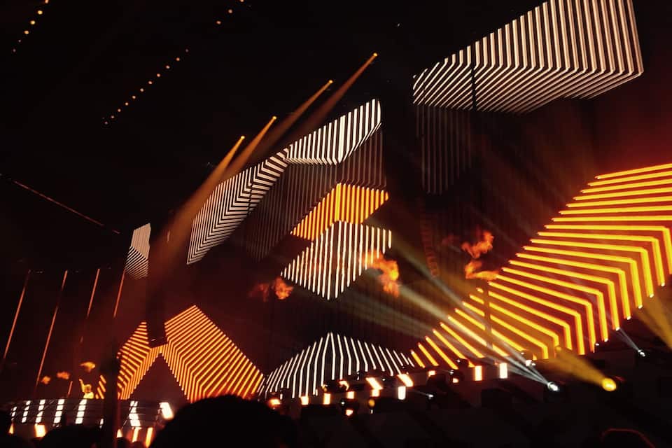 Un concert amb il·luminació d'escenari i patrons geomètrics.