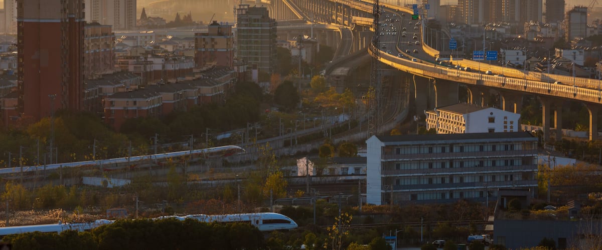 A cityscape with a prominent bridge, high-rise buildings, and a highway.