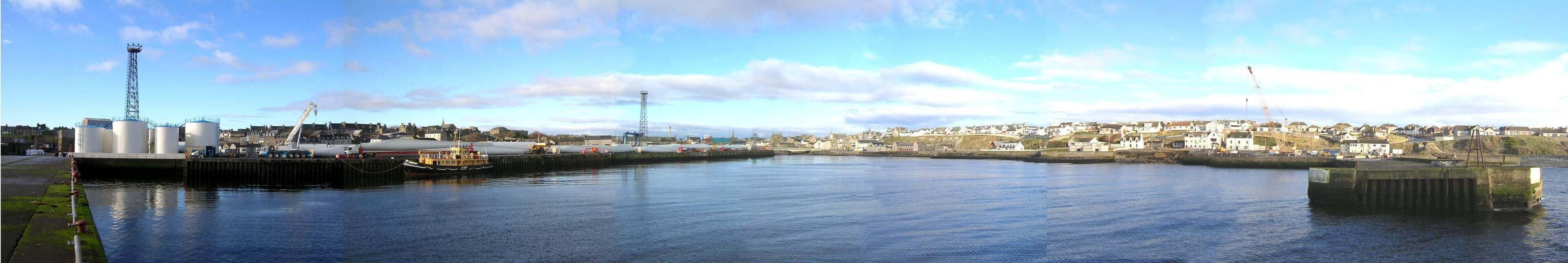 Wick Harbour, Scotland. The ex-RMAS Fleet Tender Ilchester is to the left, with windmill blades behind her.
