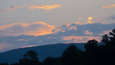 The predawn sun illuminates the clouds over the hills near Anniston, Alabama, USA