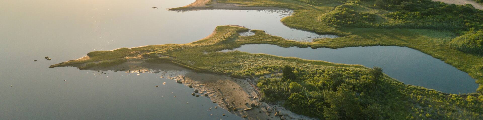 Aerial view of beach dividing Quonochontaug Pond and Atlantic Ocean at sunrise, Weekapaug, Westerly, Rhode Island, USA