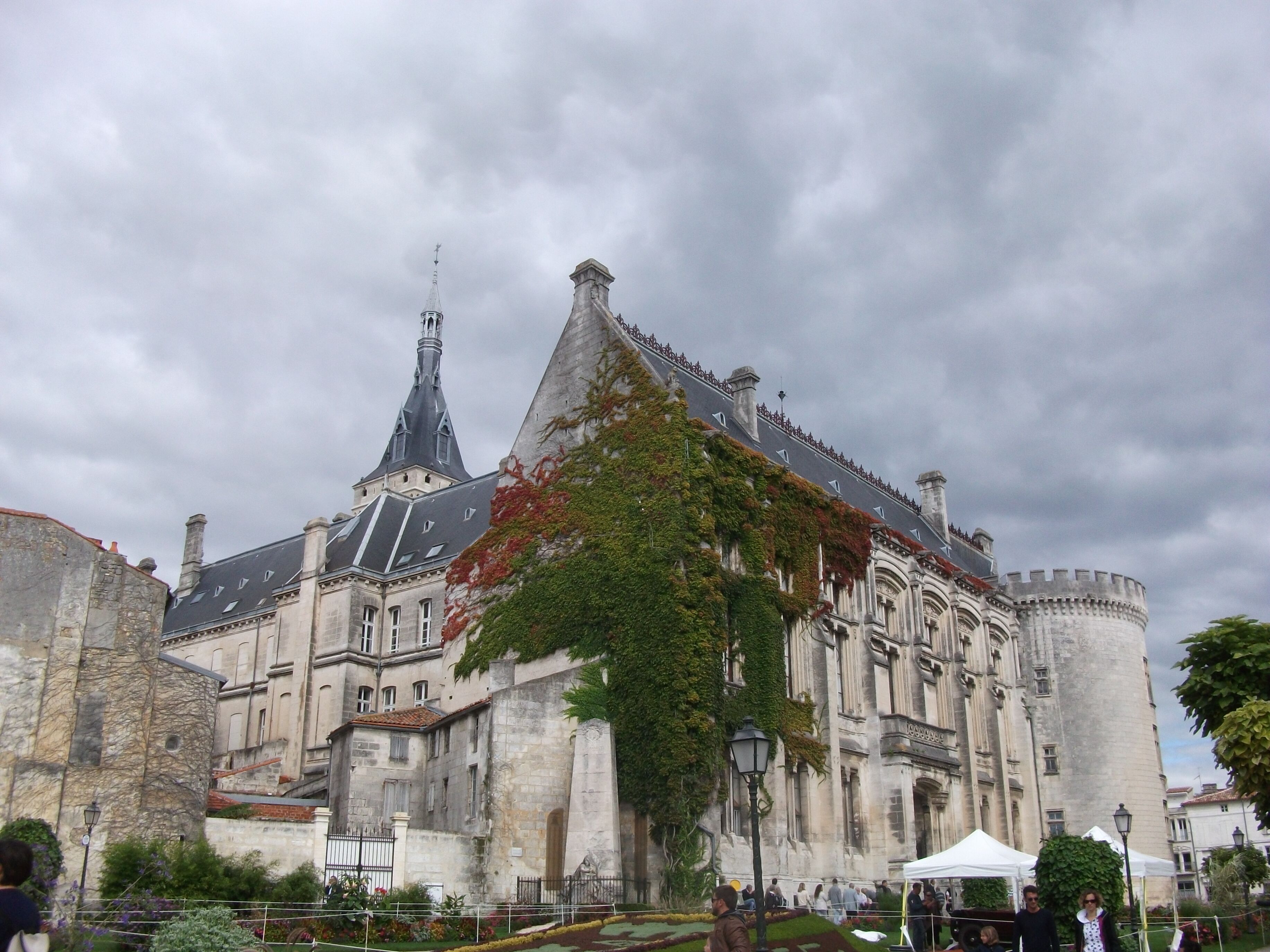 A historic building with a prominent tower and a large, fortified wall.