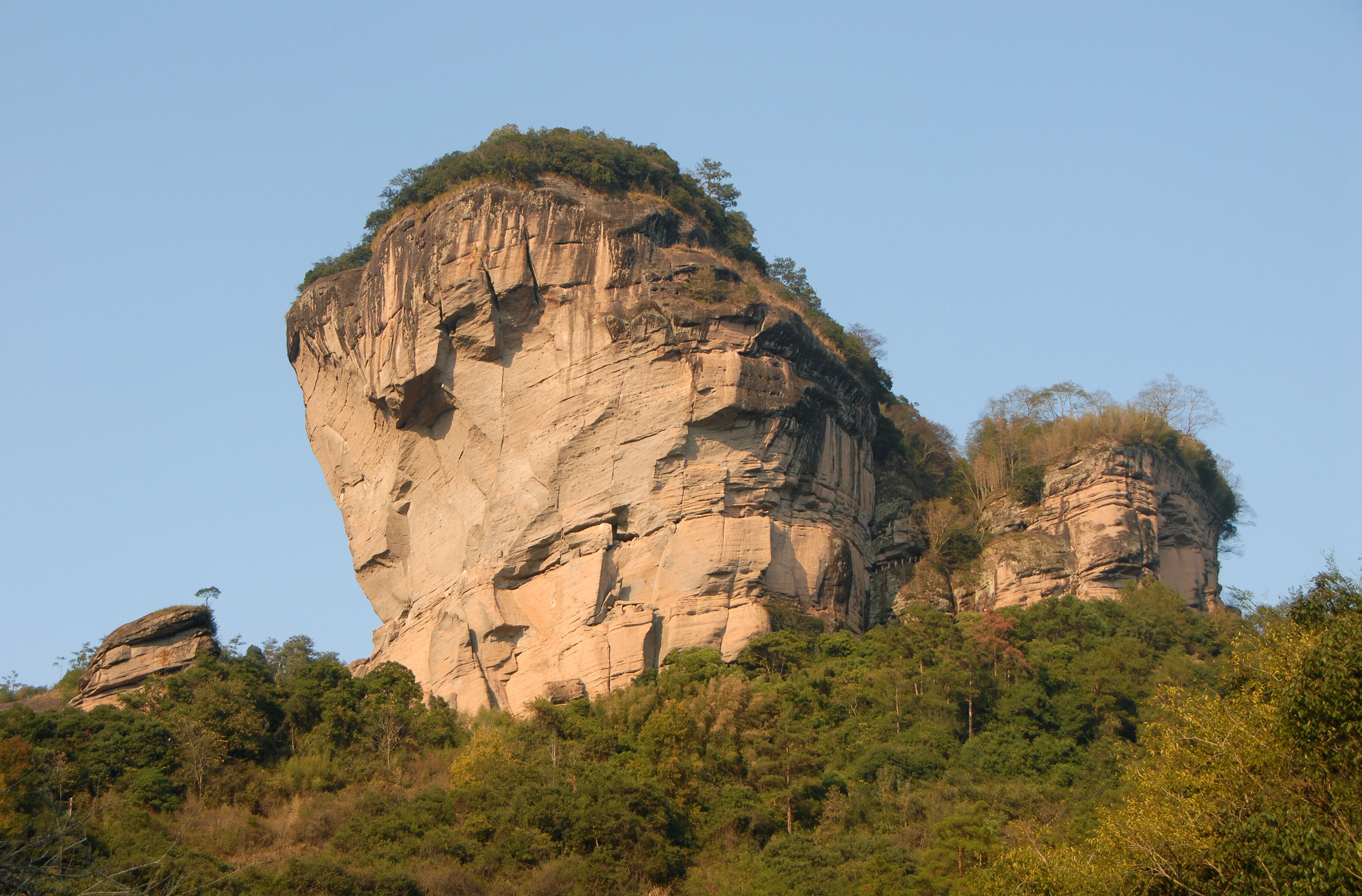 Wuyishan mountains in Fujian Province, China. View of DaWang Peak (Great King Peak) in Wuyi mountains a UNESCO World Heritage site. Close up view with forest in the foreground. Wuyishan, China.