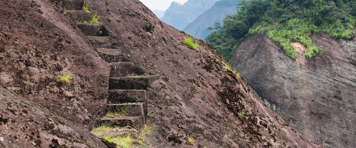A rocky hillside with a series of stone steps leading up the slope.