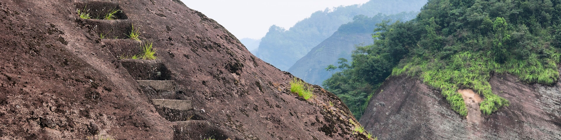 A rocky hillside with a series of stone steps leading up the slope.