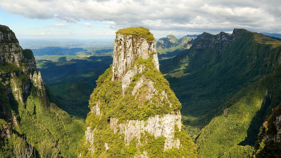 A canyon with steep cliffs and a prominent central peak.