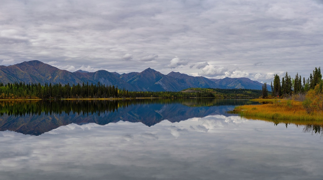 Beautiful reflection of the St. Cyr mountain range in Jackfish Lake; Ross River, Yukon, Canada
