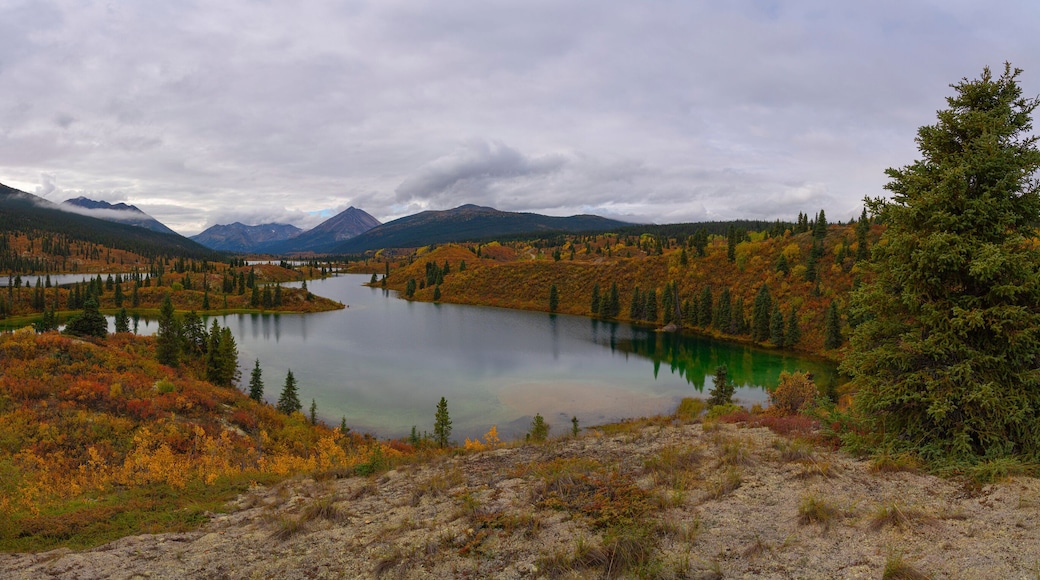 Rose Lake, Yukon with autumn colours on the hillsides; Ross River, Yukon, Canada