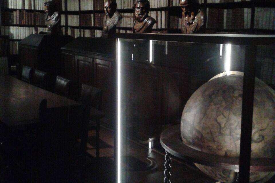 A museum exhibit with a globe and busts.