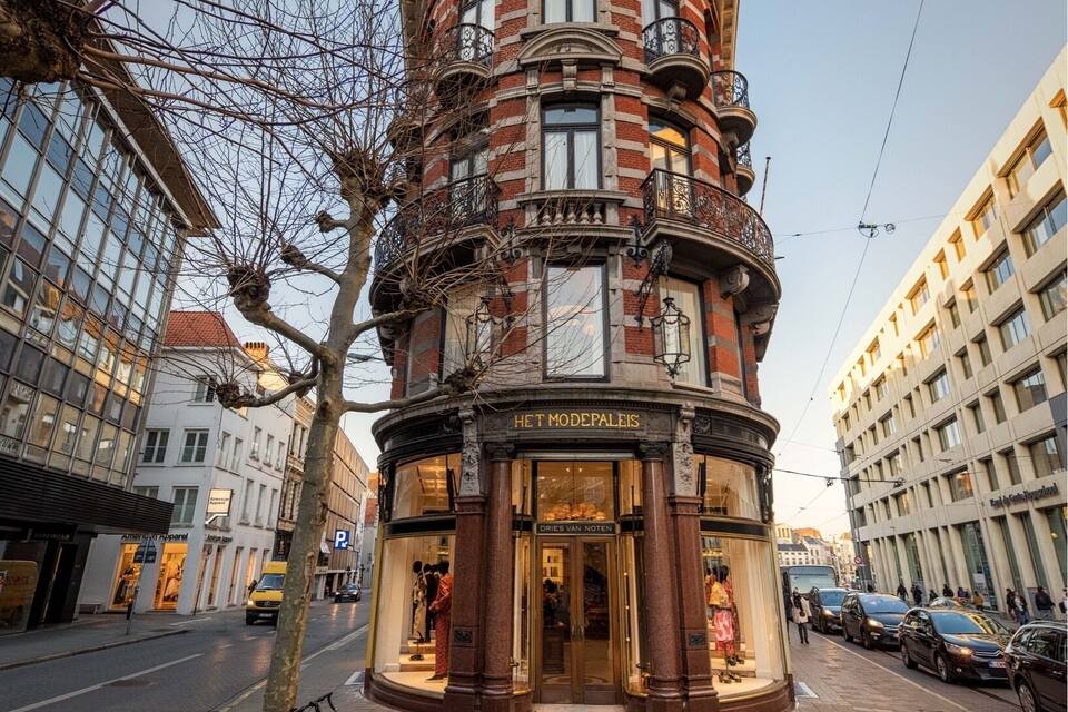 Ein historisches Gebäude mit einer gewölbten Fassade, großen Fenstern und einem Schild, auf dem