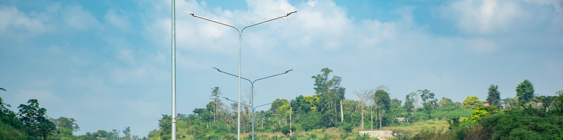 Highway linking Yaounde to Nsimalen International Airport, Cameroon. A modern and smooth road winding between green hills.
