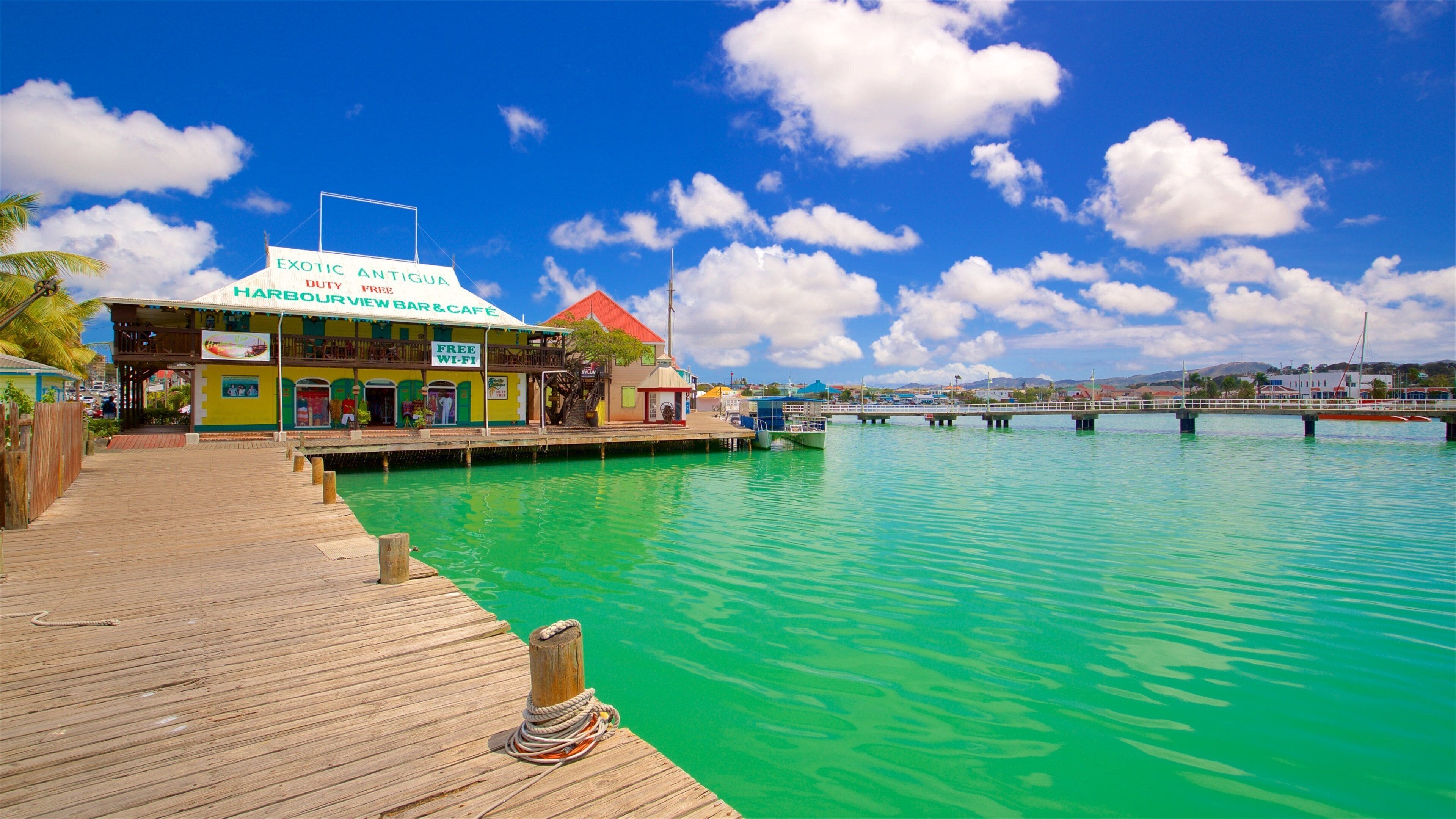 A waterfront bar and cafe named 'HARBOURVIEW BAR & CAFE' with a 'FREE WIFI' sign, a wooden dock, and a bridge in the background.