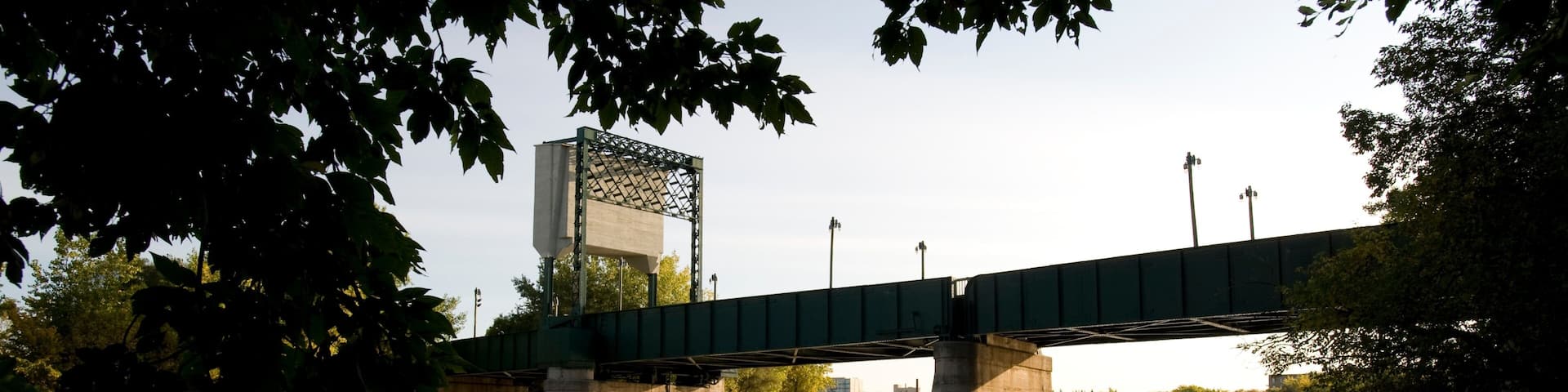 A bridge over a calm river with trees framing the scene.