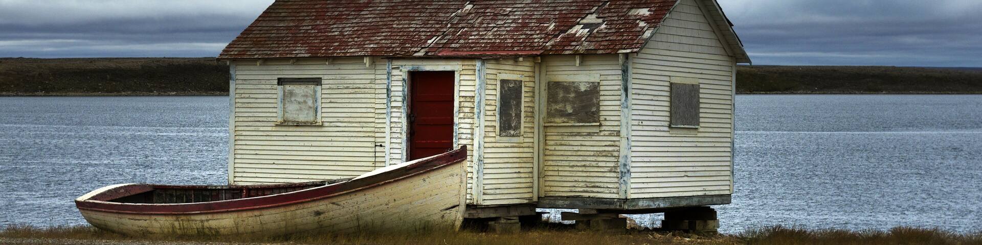 Boarded up cabin with boat