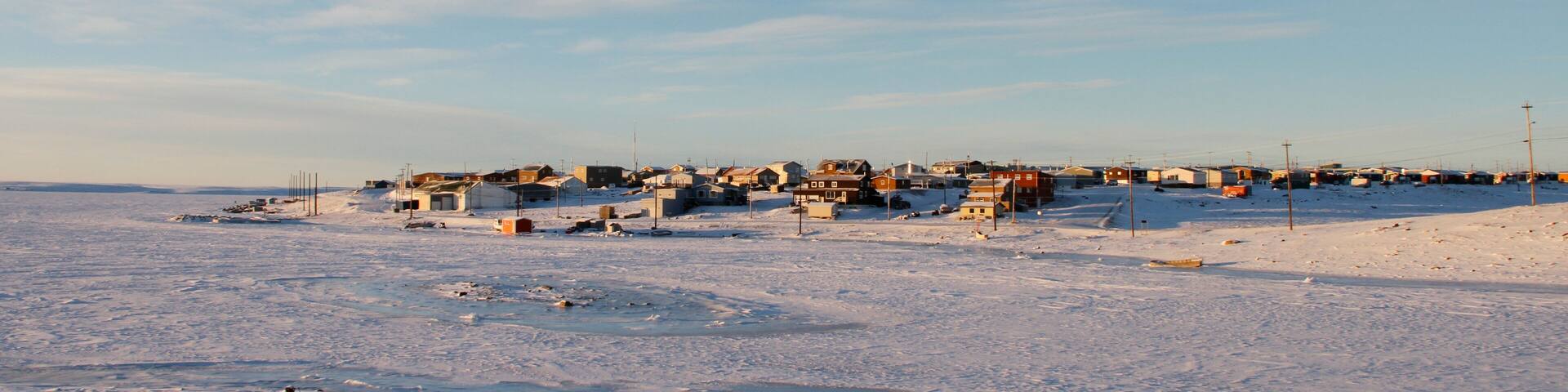 Arctic community of Cambridge Bay in the fall with snow on the ground and blue skies