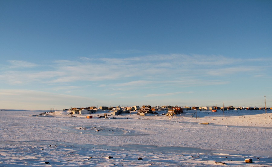 Arctic community of Cambridge Bay in the fall with snow on the ground and blue skies
