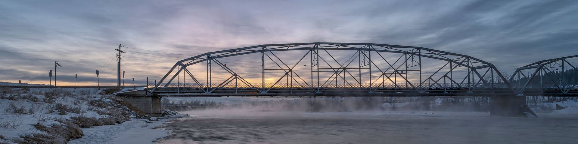 Winter sunrise on the Bow River and a bridge in Cochrane, Alberta, Canada