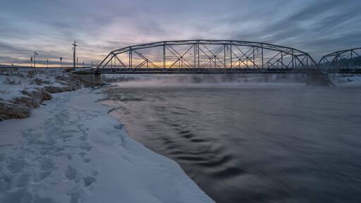 Winter sunrise on the Bow River and a bridge in Cochrane, Alberta, Canada