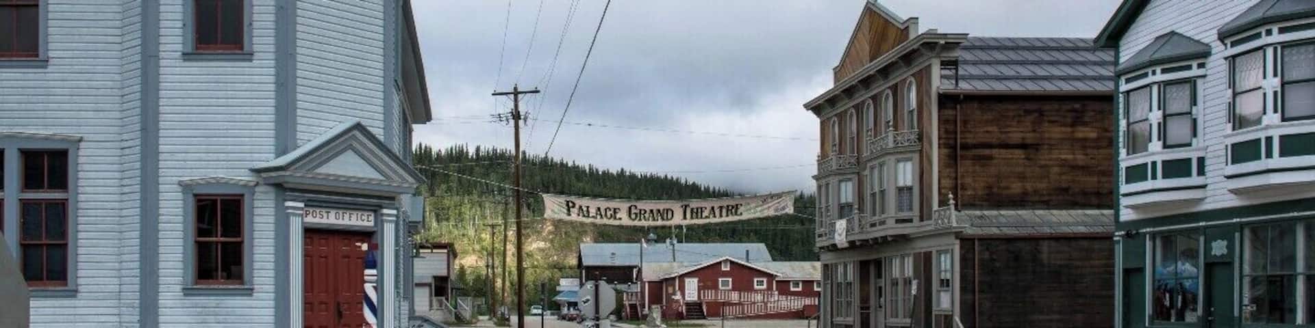 A historic town with a post office, a building labeled 'Palace Grand Theatre', and a wooden structure.