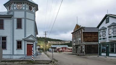 Un pueblo histórico con una oficina de correos, un edificio que dice 'Palace Grand Theatre' y una estructura de madera.