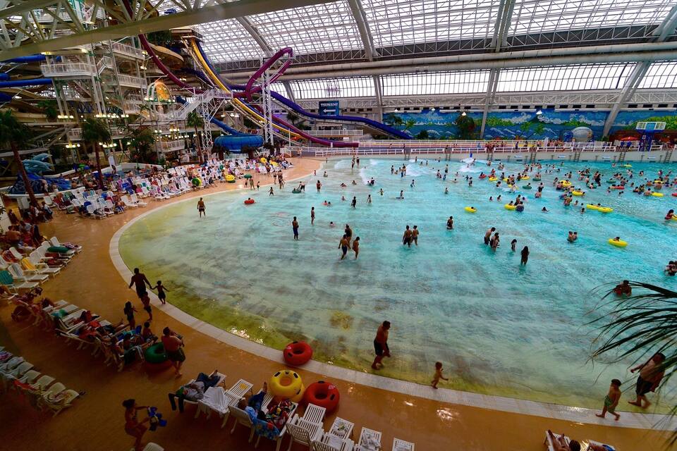 Un parc aquàtic interior amb diverses tobogans i piscines.