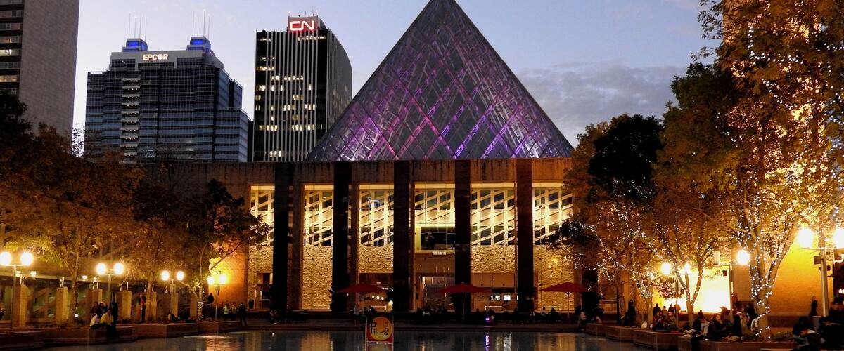 A cityscape with a prominent pyramid-shaped building, a CN-branded skyscraper, and a modern building with vertical lines.