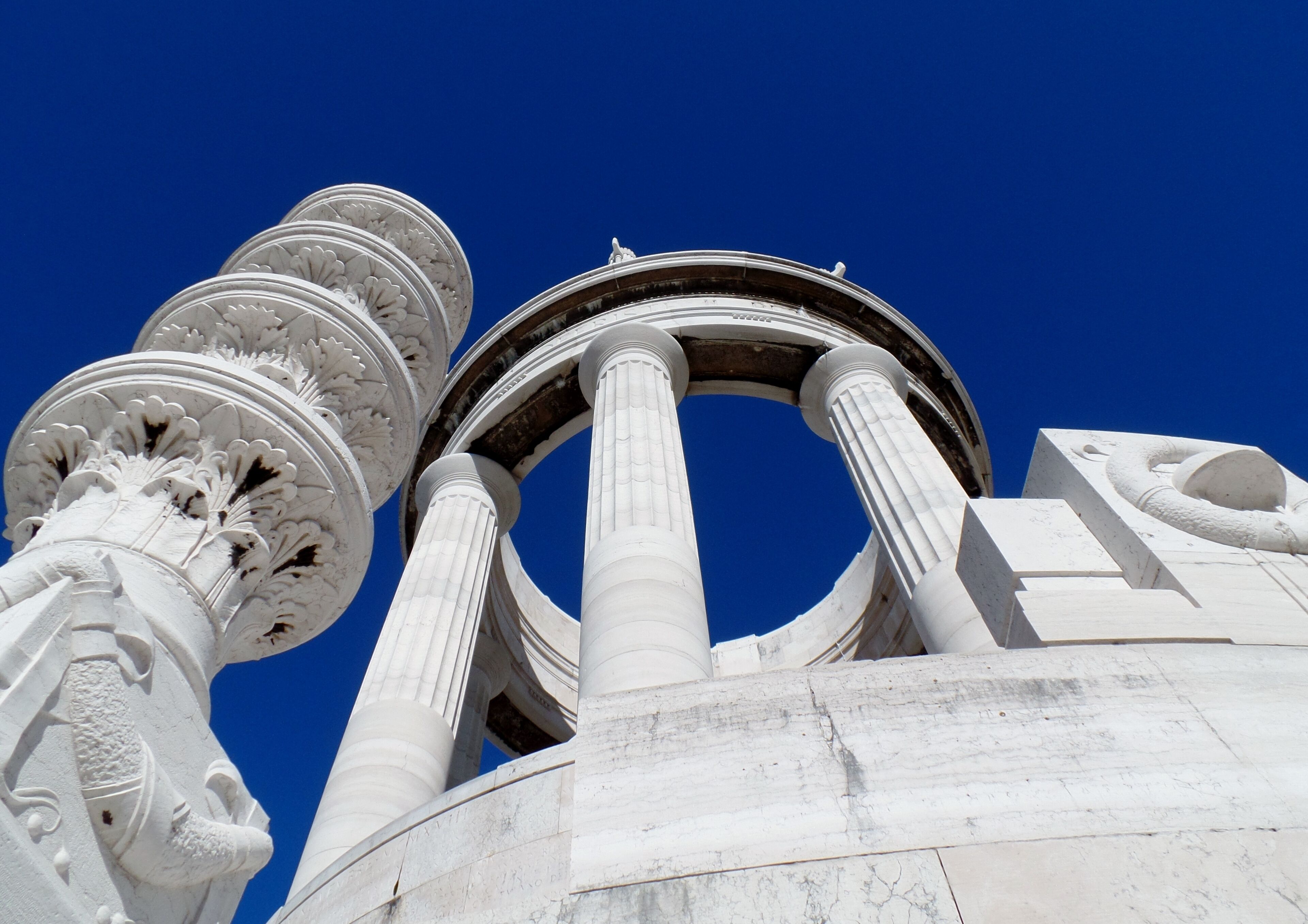 A classical architectural structure with ornate columns and a clear blue sky.