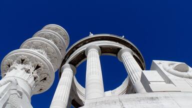 Una estructura arquitectónica clásica con columnas ornamentadas y un cielo azul despejado.