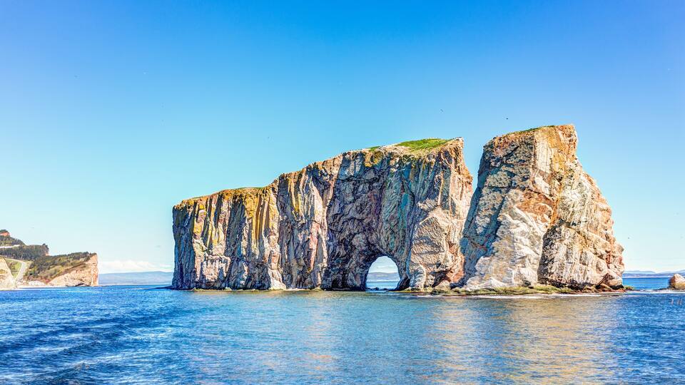 A coastal rock formation with a natural archway.
