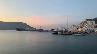 Um porto com barcos e edifícios ao pôr do sol.