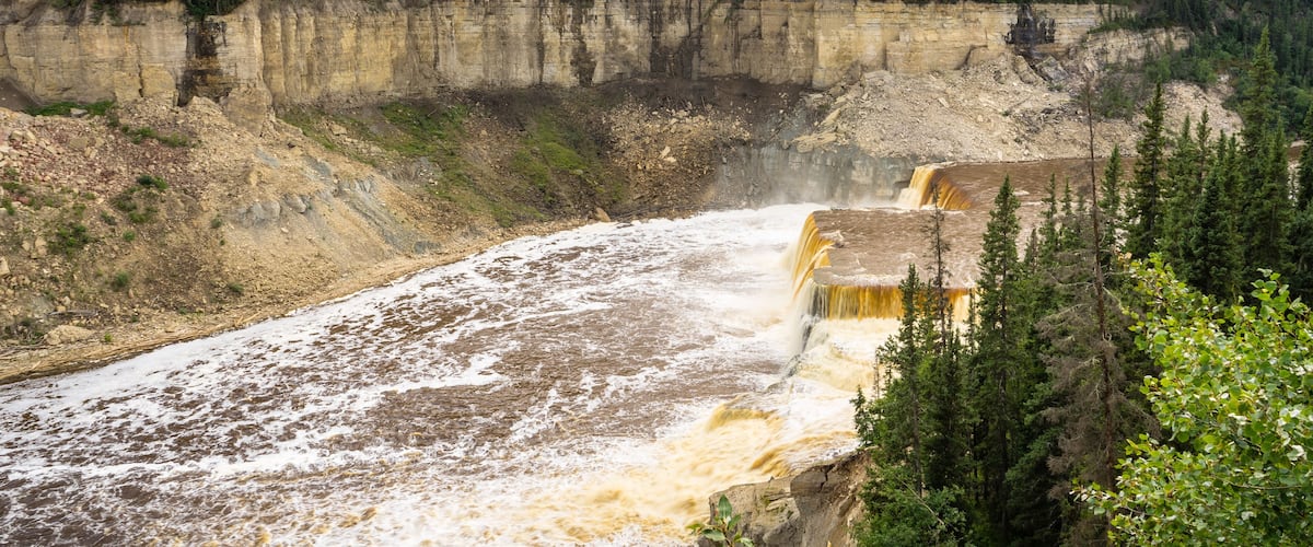 A waterfall cascading down a rocky cliff surrounded by trees.