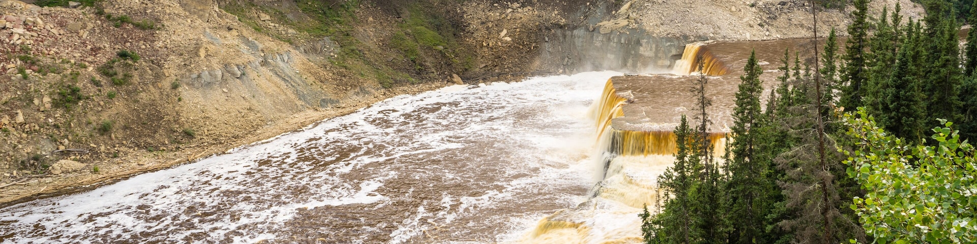 A waterfall cascading down a rocky cliff surrounded by trees.