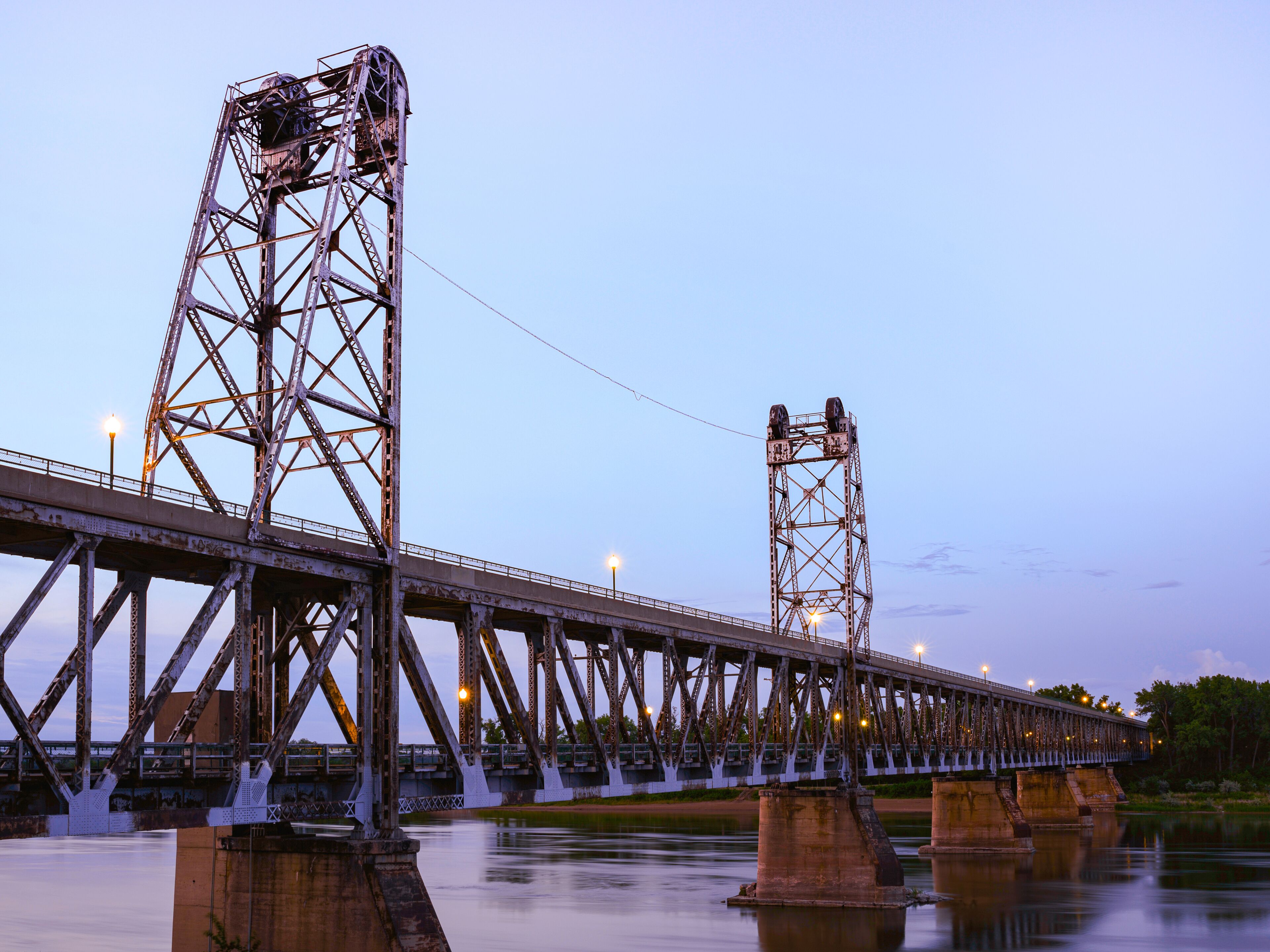 Un puente de acero grande con dos torres y un río debajo.