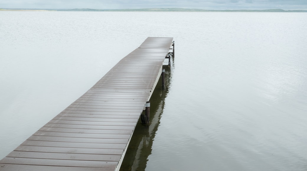 Canada, SK, Lloydminster, Manitou Lake. Weathered wooden dock juts out into the still lake.