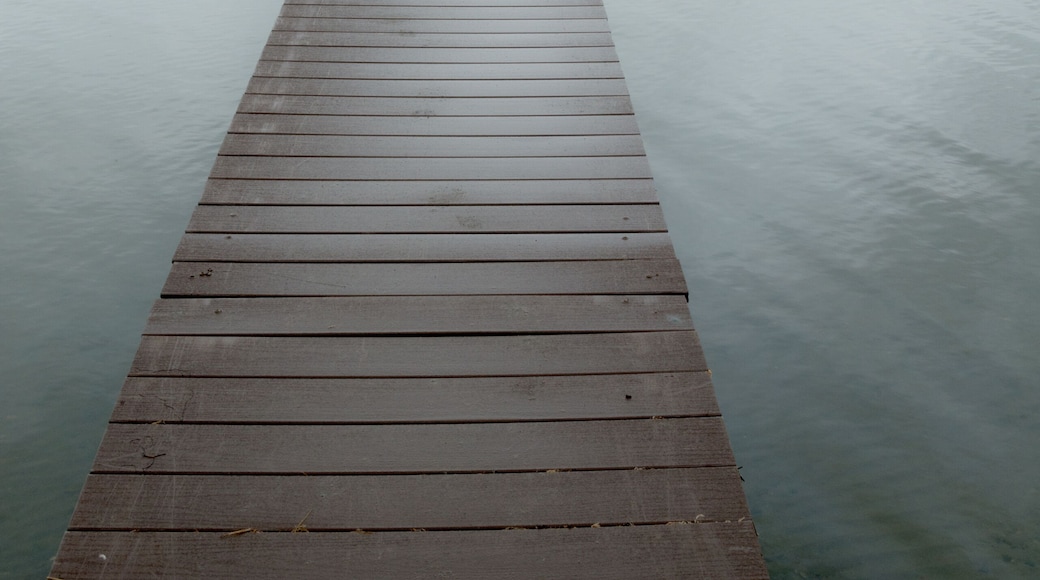 Canada, SK, Lloydminster, Manitou Lake. Weathered wooden dock juts out into the still lake.