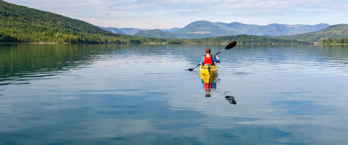 A teenage boy kayaking on White Lake, White Lake Provincial Park; British Columbia, Canada