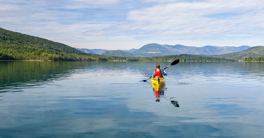 A teenage boy kayaking on White Lake, White Lake Provincial Park; British Columbia, Canada